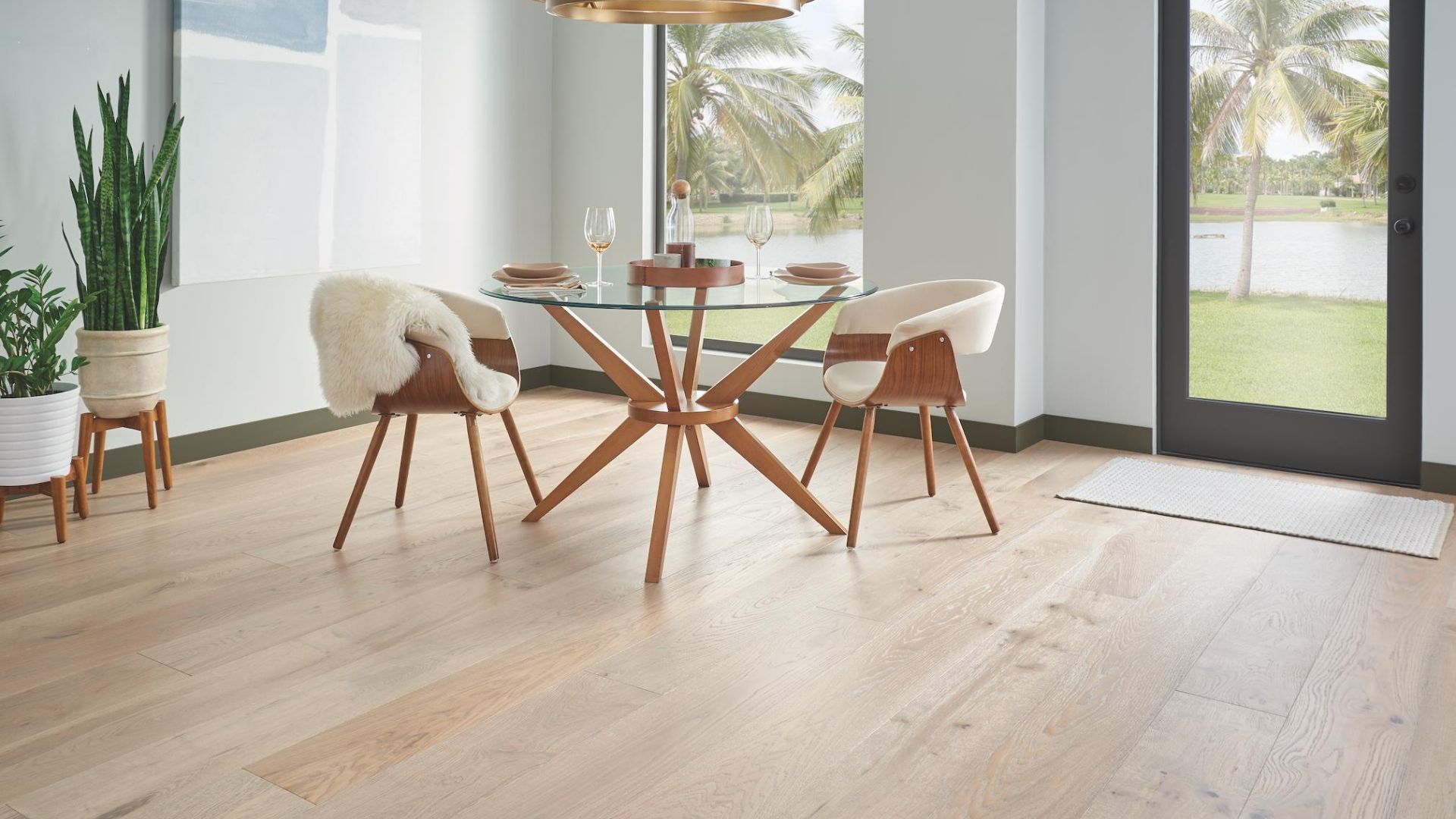 light hardwood floors in a bright dining room with glass table